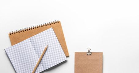 White designer office desk table with Notebook, pencil and envelope . Top view with copy space, flat lay.