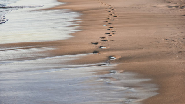 footprints in the sand from the feet of a lost person. no way out of the situation. return to the be