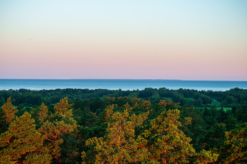 misty and cloudy sunrise above green fields and forests