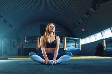Fototapeta na wymiar Stretching gymnast girl doing yoga exersizes. View of attractive young woman doing lotus pose