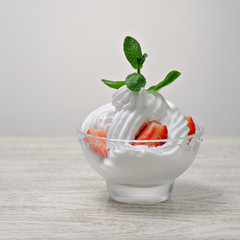 whipped cream in a cup with strawberries.