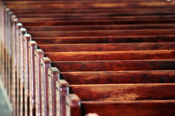 Rows of church benches. Polished wooden pews. Blurred focus.