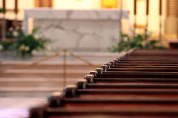 Rows of church benches. Sunlight reflection on polished wooden pews. Selective focus.