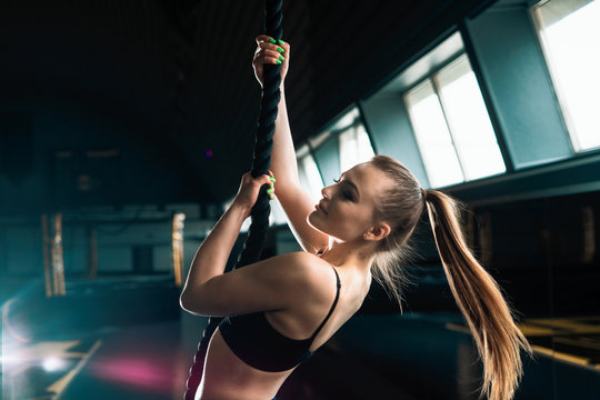Full length narrow angle shot of a woman with climbing rope.  Copyspace background with athletics healthy composition. Crossfit and fitness