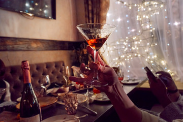 Glass of wine in hand on the background of the table