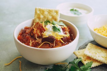 Homemade Chili bowl served with crackers, selective focus