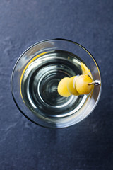 Martini cocktail with green olives. Slate background. Close up. Top view.