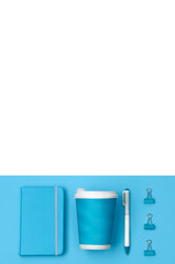 Creative top view flat lay of woman desk with with blue stationery set. Notepad, pen, clip and coffee cup