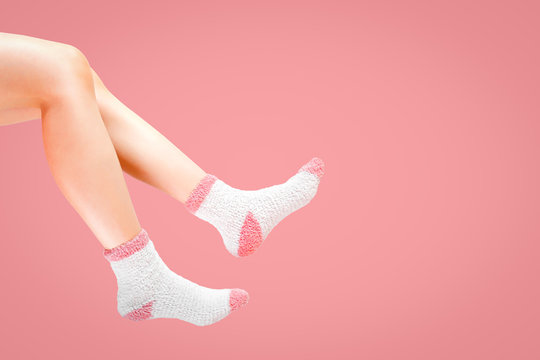 Legs Of Woman With Fashion Socks On Pink Background. Wearing Winter Socks.