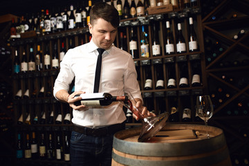 handsome elegant serious man in the wine cellar. close up photo. free time, job, profession. copy space