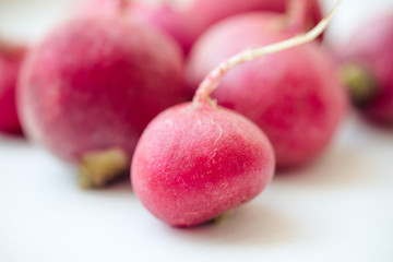 several ripe radishes on a white table