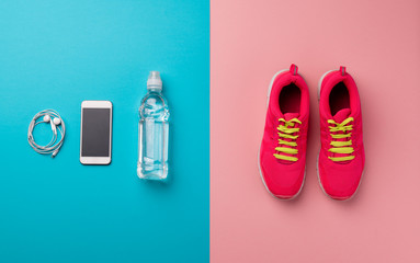 A studio shot of running shoes and smartpone on color background. Flat lay.