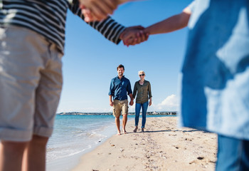 Young family with two small children outdoors on beach.
