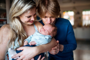 Beautiful young parents with a newborn baby at home.