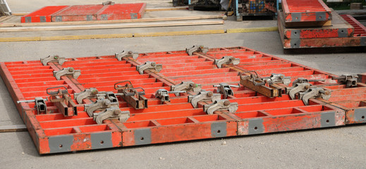 red painted metal formwork elements at construction site