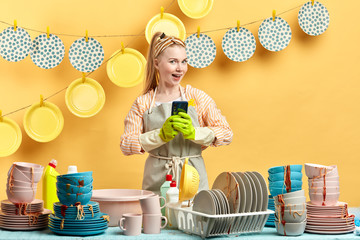 cheerful young woman having a chat with a boyfriend while cleaning the kitchen. close up portrait.