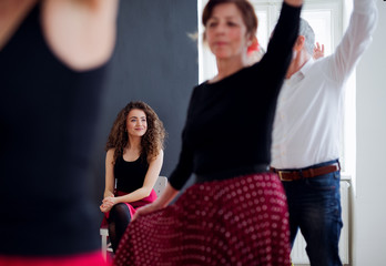 Group of senior people in dancing class with dance teacher, midsection.