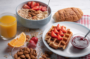 Traditional breakfast - sweet belgian waffle and fruit oatmeal porridge with berry, fruit and nuts on white background. Morning food set