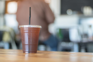 Iced Americano coffee in plastic glass.Indoor cafe.