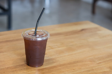 Iced Americano coffee in plastic glass.Indoor cafe.