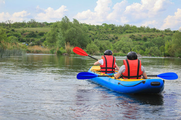 Young couple enjoy white water kayaking on the river, extreme and fun sport at tourist attraction. Rafting on the  Pivdennyi Buh River. Active adventure couple along the river