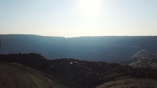 Open pit coal mine, extractive industry for coal, top view aerial drone at sunset