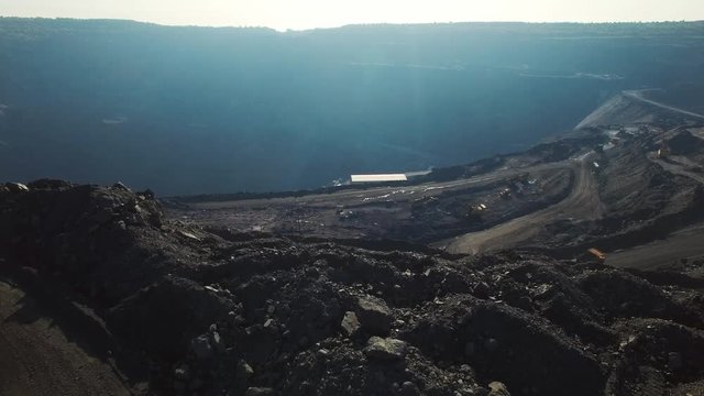 Open pit coal mine, extractive industry for coal, top view aerial drone at sunset