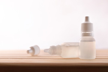 Plastic bottle with eye medication on wooden table