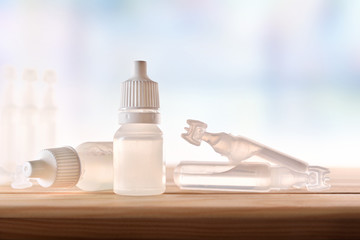 Plastic bottle and pipettes with eye medication on table room
