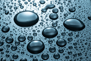 Drops of water on a blue glass texture background
