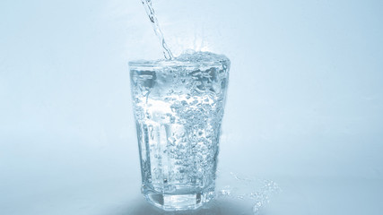 water pouring in glass on white background