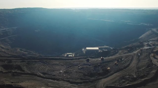 Open pit coal mine, extractive industry for coal, top view aerial drone at sunset