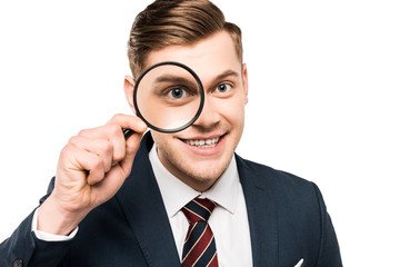 Fototapeta na wymiar cheerful businessman holding magnifying glass near eye isolated on white