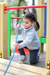 a child is climbing a tightrope in the playground