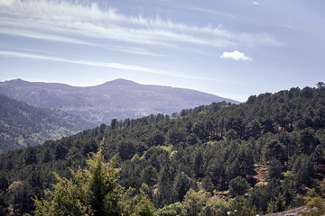 Fototapeta na wymiar Panoramic of some mountains under a cloudy blue sky