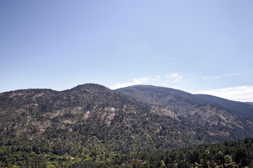 Panoramic of some mountains under a cloudy blue sky