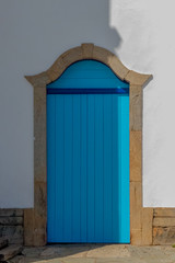 Colonial blue door with frame in stone and made in wood, church of Pirenopolis