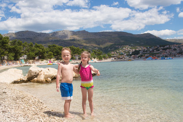 Fototapeta na wymiar Happy children embrace each other on the beach, Croatia, Split
