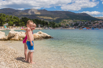 Happy children embrace each other on the beach, Croatia, Split