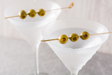 Classic Dry Martini with olives on gray background. Close up