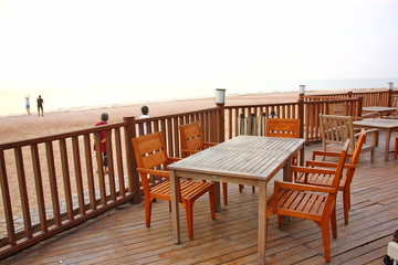 Fototapeta na wymiar wood terrace with wooden table and desk on beach at sea view point.the restaurant on beach ,that there are wood components