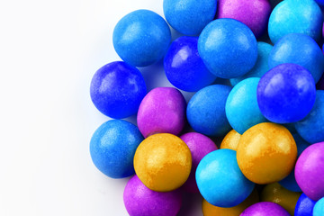 A rainbow of color from multicolored candies close-up, multi-colored glaze dragee on a white background