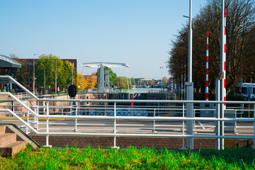 Fototapeta na wymiar red traffic light, iron lock, water navigation with bridge, in fortified city Gorinchem, The Netherlands