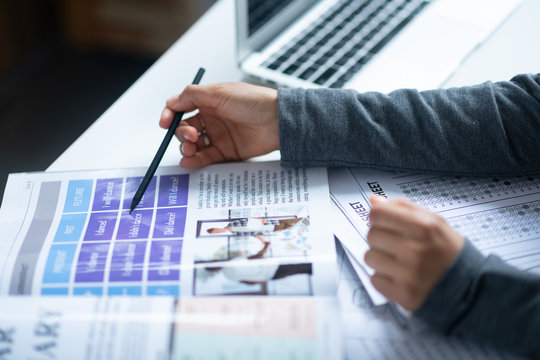 Teacher holding pen reading grammar book before lesson