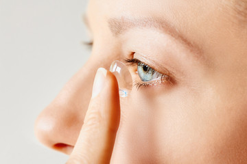 Young woman puts contact lens in her eye. Eyewear, eyesight and vision, eye care and health, ophthalmology and optometry concept, selective focus