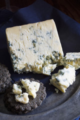 Mature English Stilton cheese with charcoal crackers with low key light