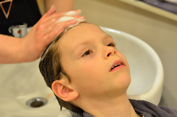 Naklejka premium Kind werden beim Friseur die nassen Haare gewaschen