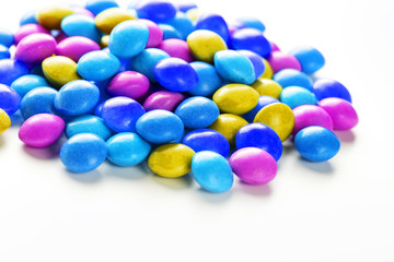 A rainbow of color from multicolored candies close-up, multi-colored glaze dragee on a white background