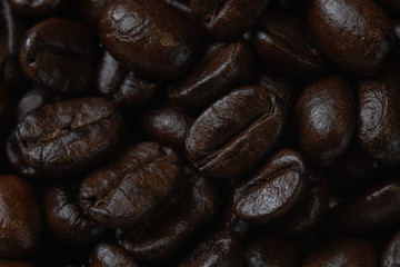 Naklejka premium close up of pile roast coffee beans on wooden board