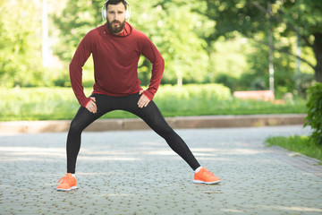  Young male jogger athlete training and doing workout outdoors in city.